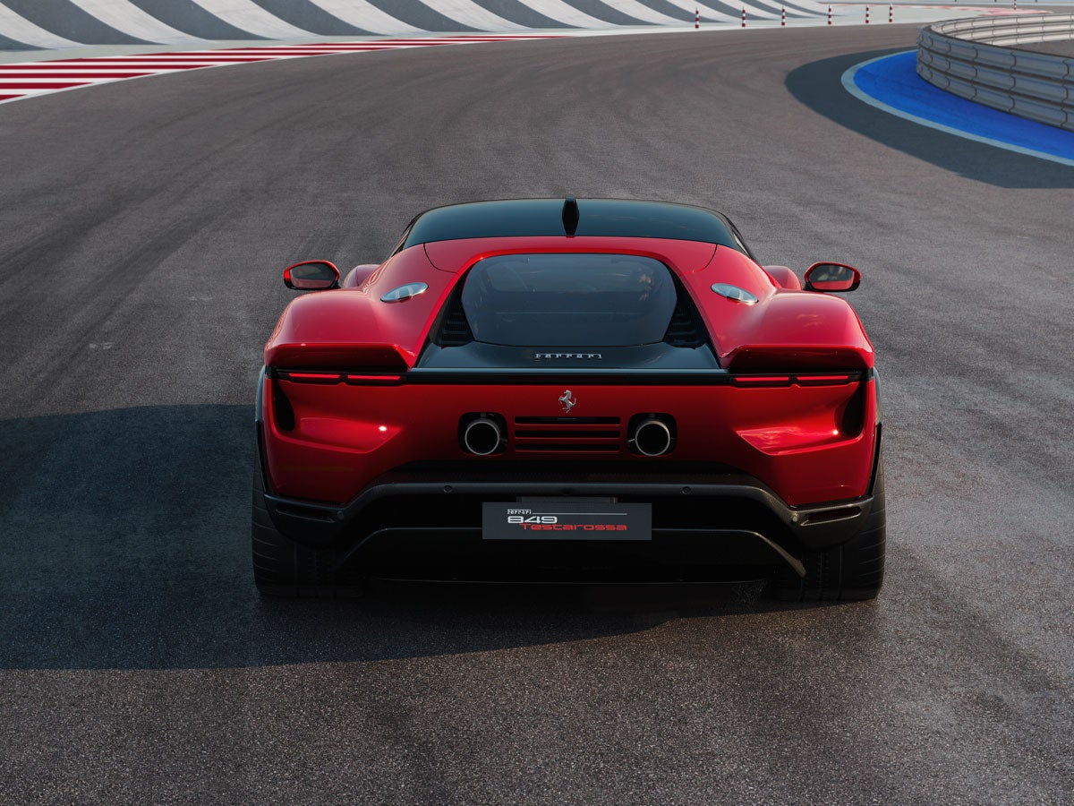 Rear view of a red Ferrari 849 Testarossa on a racetrack.
