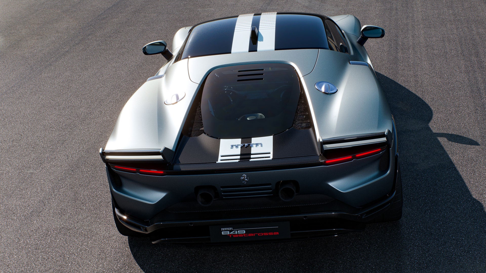 Top-down view of a light gray Ferrari with two white stripes extending from front to back, on asphalt.