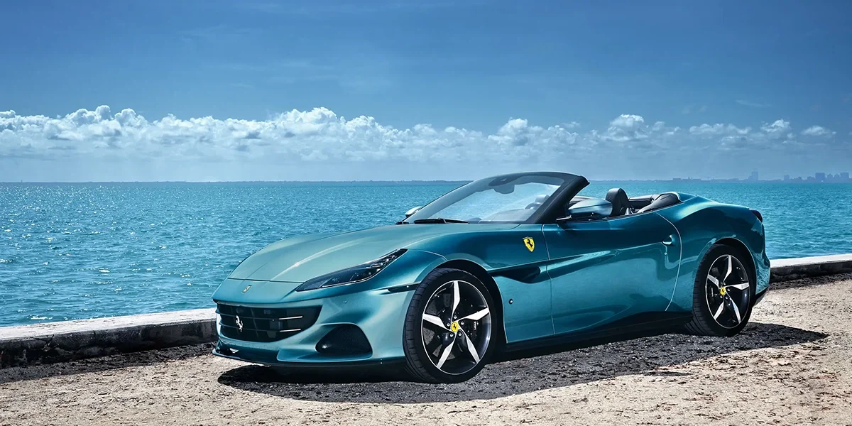 Ferrari Portofino M parked by colorful seaside buildings