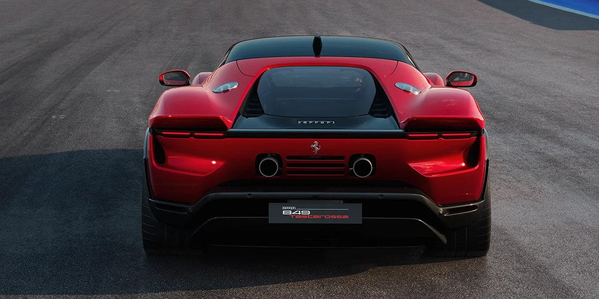 Direct rear view of the Ferrari 849 Testarossa in red, displaying dual exhaust pipes, aerodynamic vents, and wide rear stance.